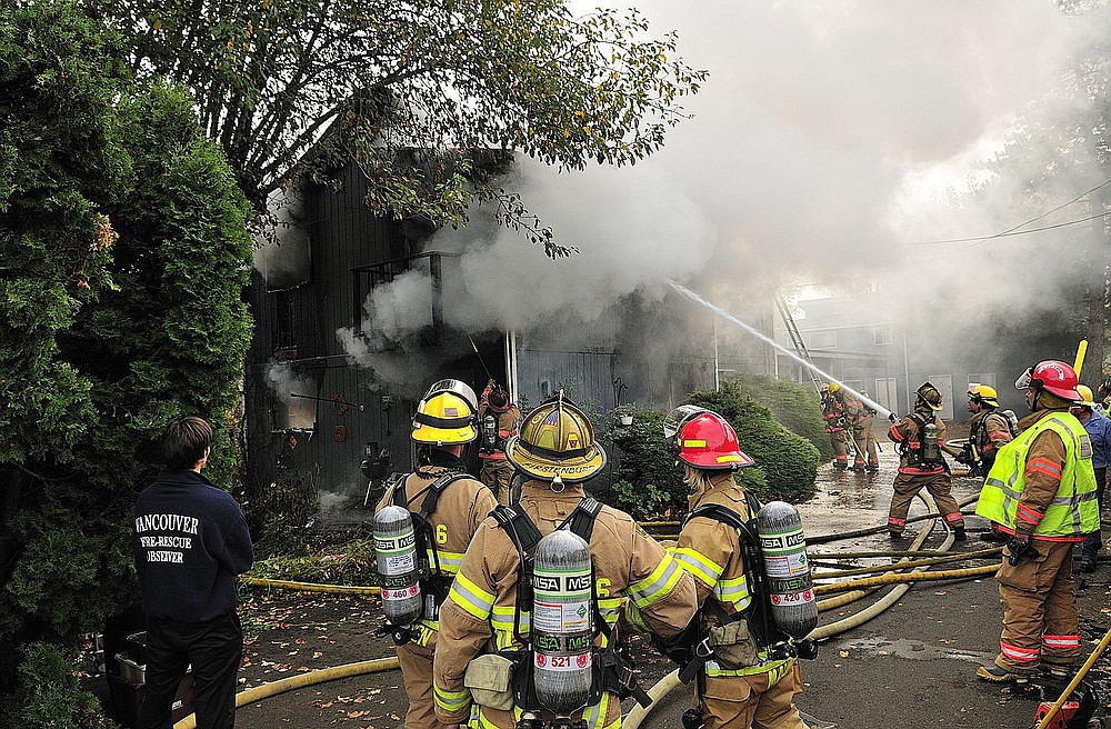 Photos by Troy Wayrynen/The Columbian
A two-alarm fire in Vancouver's Harney Heights neighborhood Tuesday destroyed two townhouses and sent a woman to the hospital with smoke inhalation and burn injuries, according to the Vancouver Fire Department.