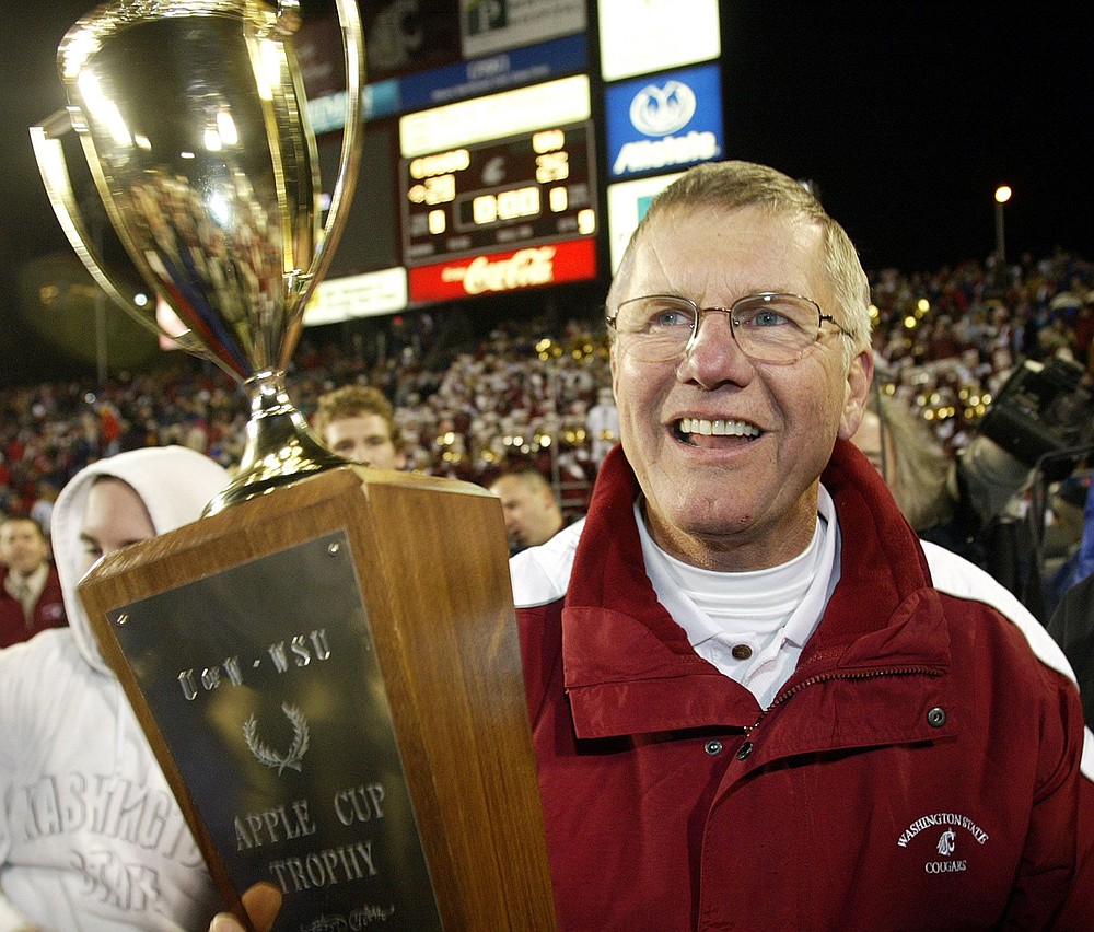 ** FILE ** Washington State head coach Bill Doba holds the Apple Cup trophy after his team beat Washington 28-25 in this Nov. 20, 2004, file photo in Pullman, Wash. Doba is looking for a little consistency this season after last year's team was slowed by injuries and inexperience and fell to a 5-6 record. (AP Photo/Ted S.