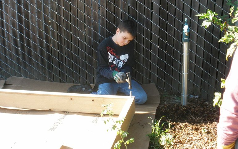 Jaden Wahl was one of the people who volunteered to install 15 raised garden beds and spread wood chips in the walkways between the beds Nov.