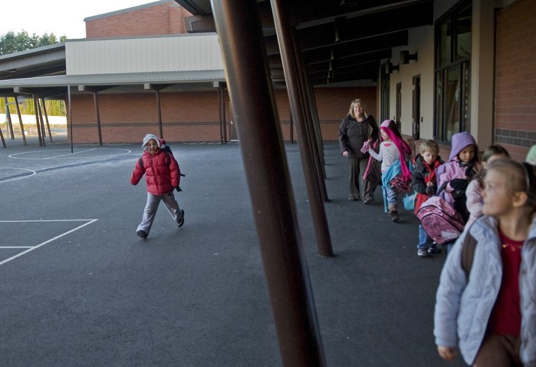 Mary Patterson, back center, leads her kindergarten class outside at the end of school on Tuesday at Endeavour Elementary School.