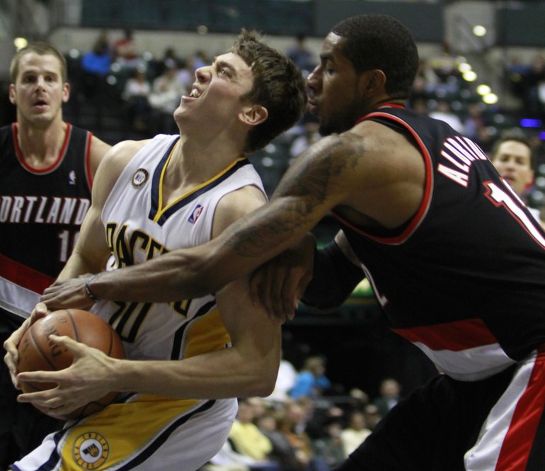 Indiana Pacers forward Tyler Hansbrough, front left, is fouled by Portland Trail Blazers forward LaMarcus Aldridge, right, during the fourth quarter of an NBA basketball game in Indianapolis, Wednesday, Dec. 9, 2009. Portland won 102-91.