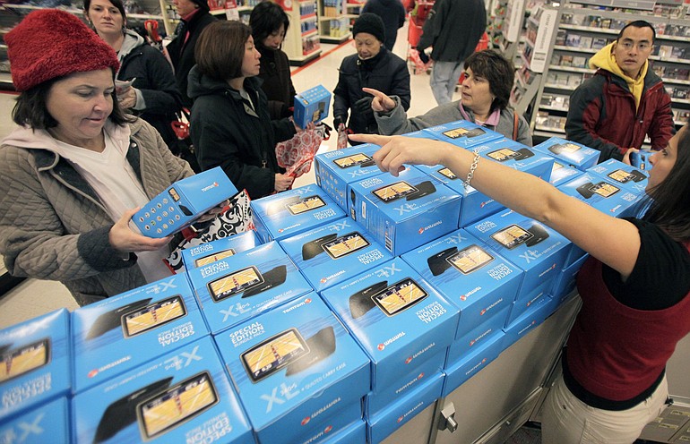 FILE - In this Friday, Nov. 27, 2009 file photo, shoppers look at TomTom GPS devices at a Target store in Mayfield Heights, Ohio. Americans got wealthier for a second straight quarter in the fall, as the economic recovery again boosted home values and investments.