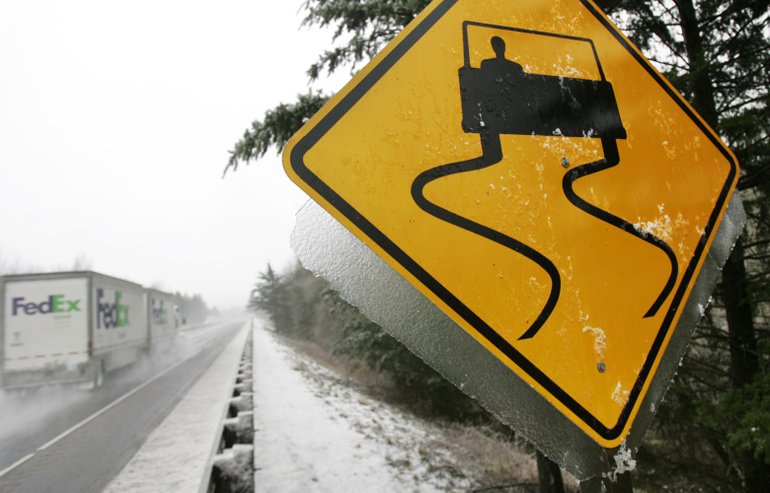 Traffic heads east on Interstate 84 past an ice-covered sign near Bonneville, Ore., after the freeway was closed overnight on Nov. 30, 2006.