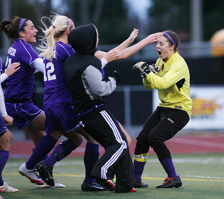 Patrick Hagerty/For The Columbian
Columbia River's goalkeeper Teagan Ryan, right, is mobbed by her teammates after after making her third save of the penalty kick shootout against Mercer Island, giving the Chieftains the Class 3A girls soccer state championship.