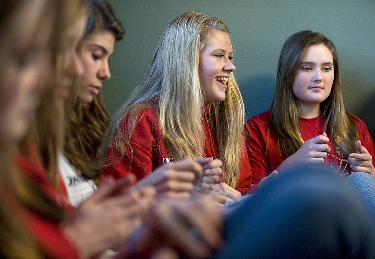 Courtney Newell, center, and Sammy Savage, right, make bracelets with friends Friday for Valentines Day gift bags.