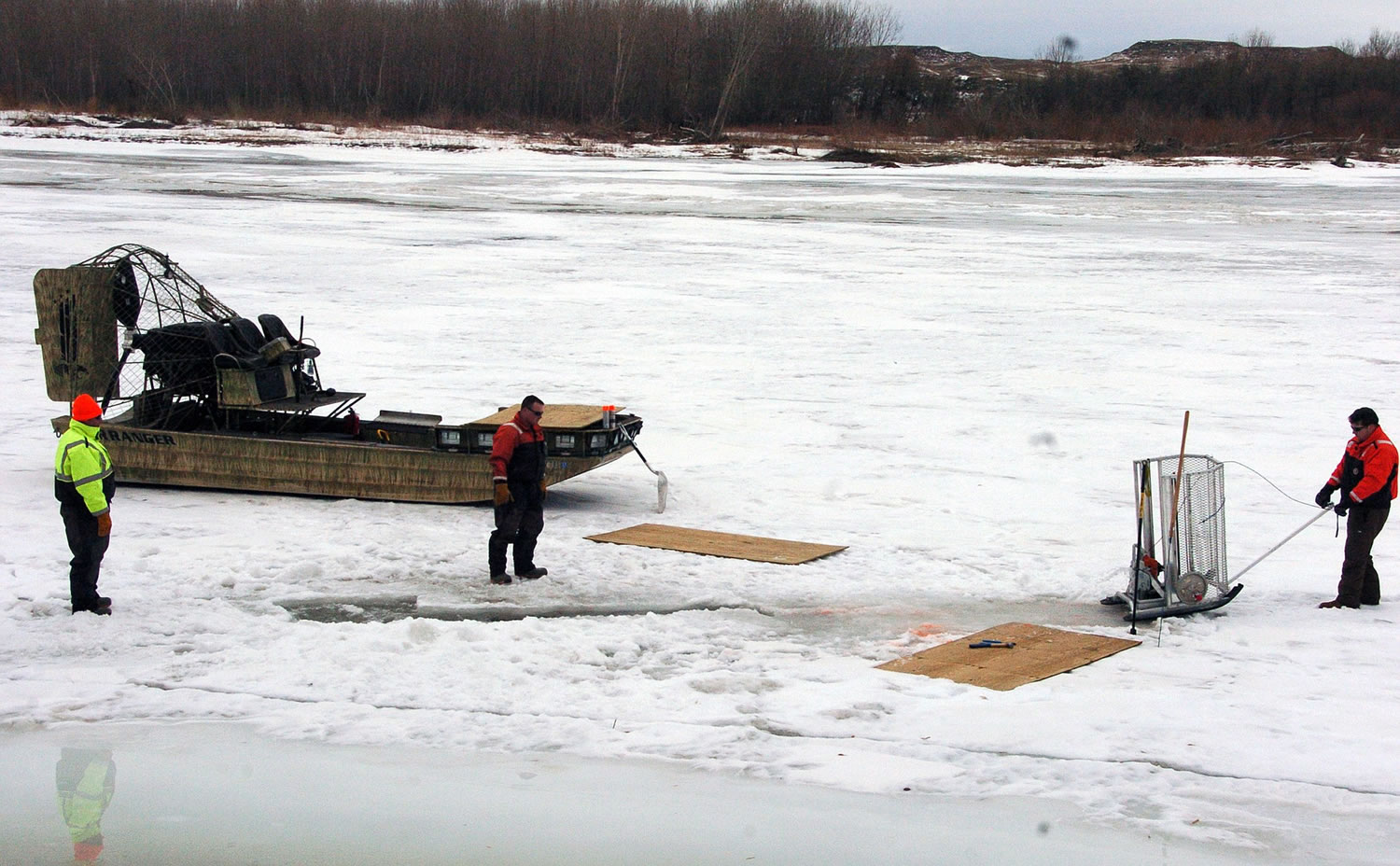Cleanup workers cut holes into the ice on the Yellowstone River near Crane, Mont., on Monday as part of efforts to recover oil from an upstream pipeline spill that released up to 50,000 gallons of crude.
