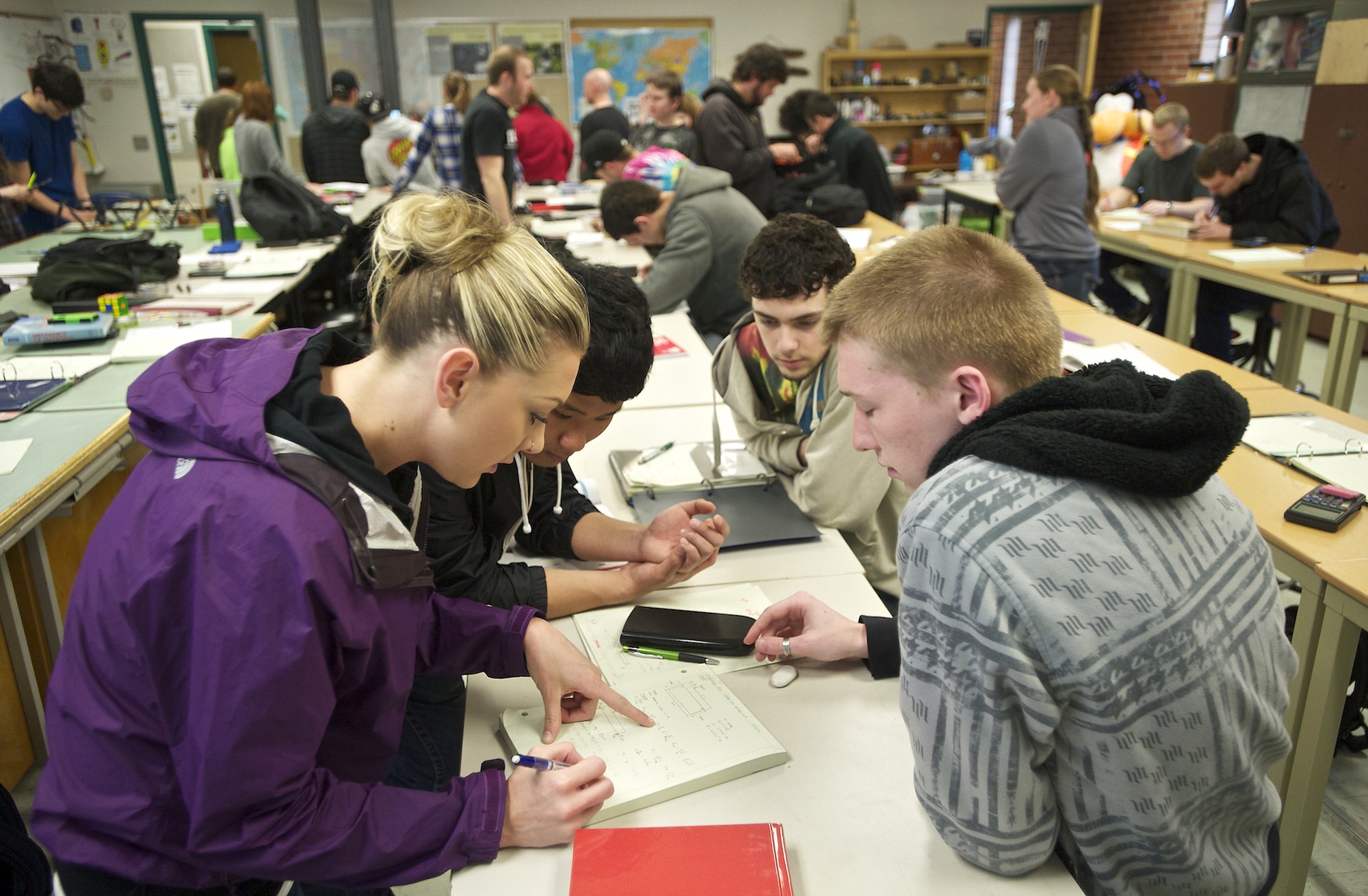 Veronique Johnson, 26, of Vancouver, from left, leads team members -- Seunghyun Roh, 20, of Vancouver, Sam Scofield, 19, of Battle Ground, and Ryan Medick, 19, of Vancouver -- through a lesson in material strength at Clark College.