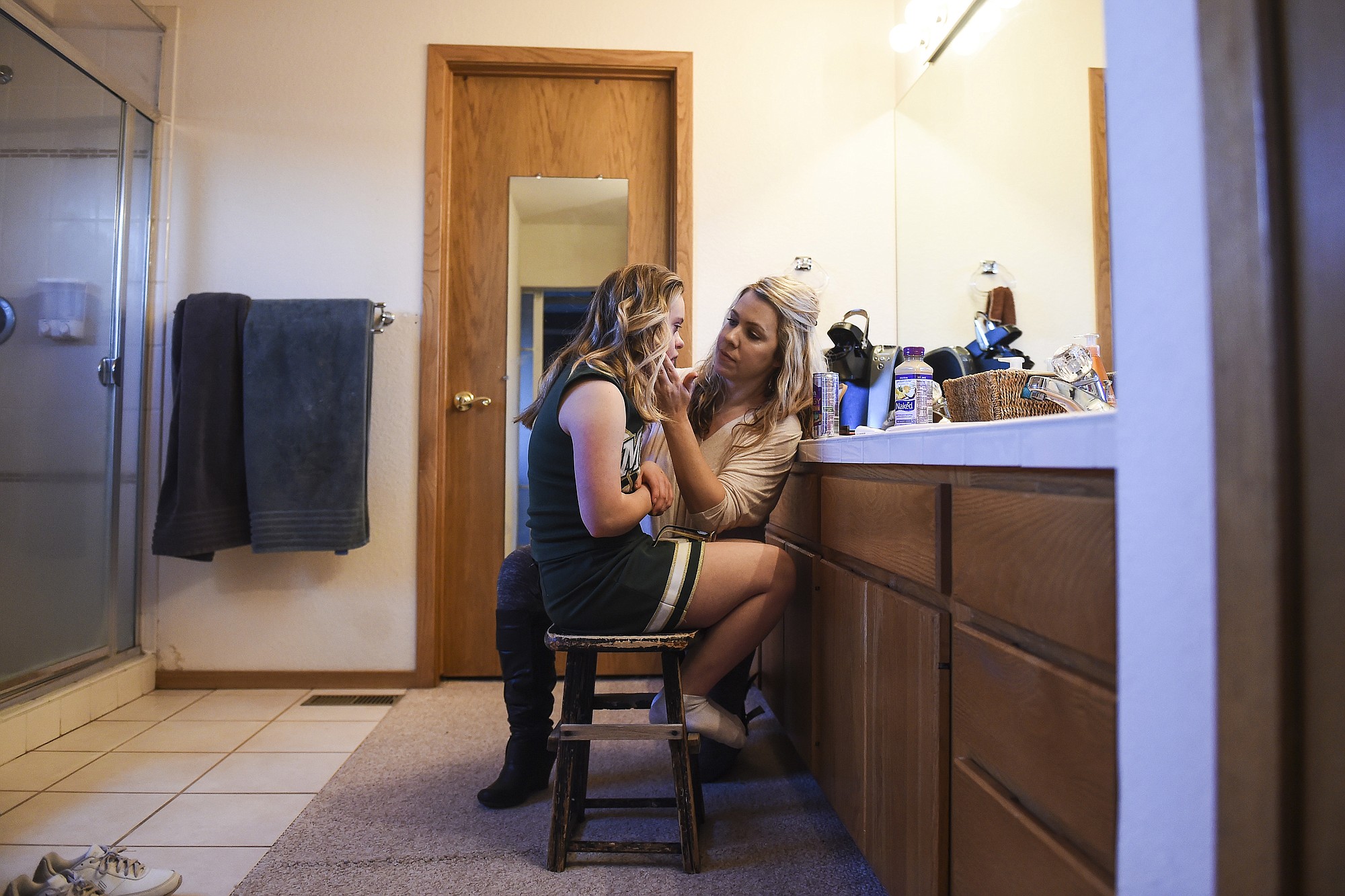 Bonnie King, right, helps her daughter and Manitou Springs varsity cheerleader Kory Mitchell, 16, put on her makeup before a Feb.