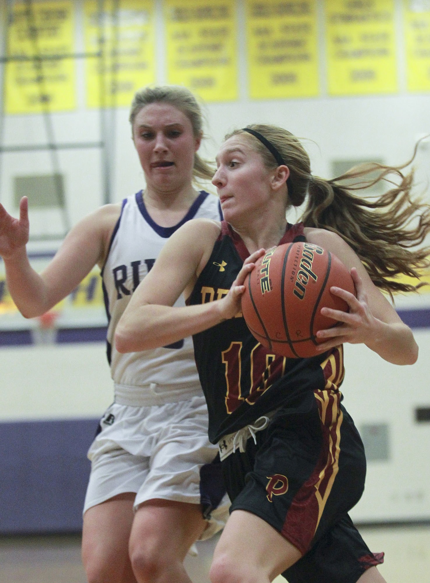 Lindsay Asplund of Prairie High School holds the ball as Megan Bloom of Coulmbia River looms behind her at a basketball game  in Vancouver Tuesday January 13, 2015.