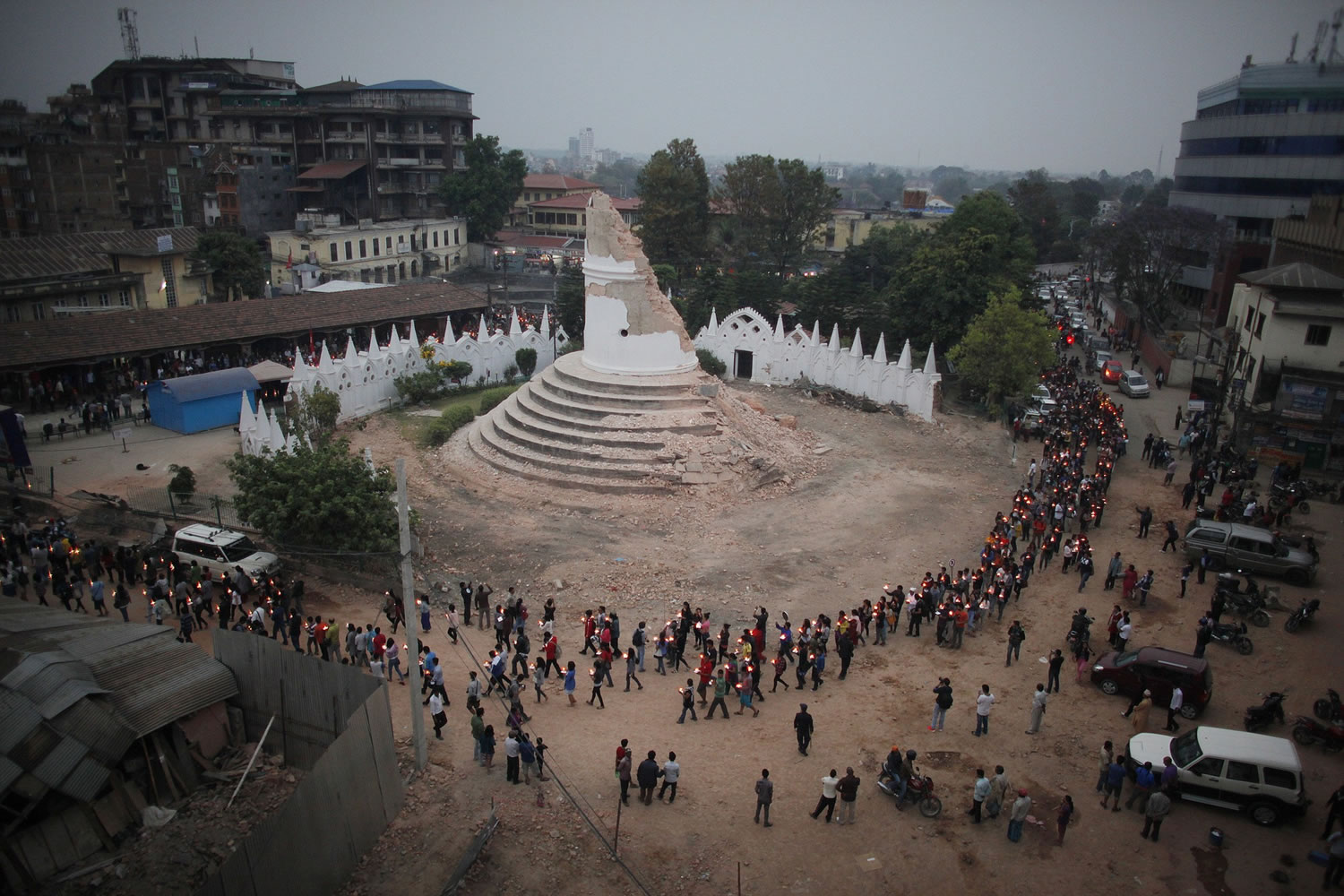People pay tribute to the victims of the April 25 earthquake as they walk with candles Thursday past the destroyed Dharahara tower in Kathmandu, Nepal.