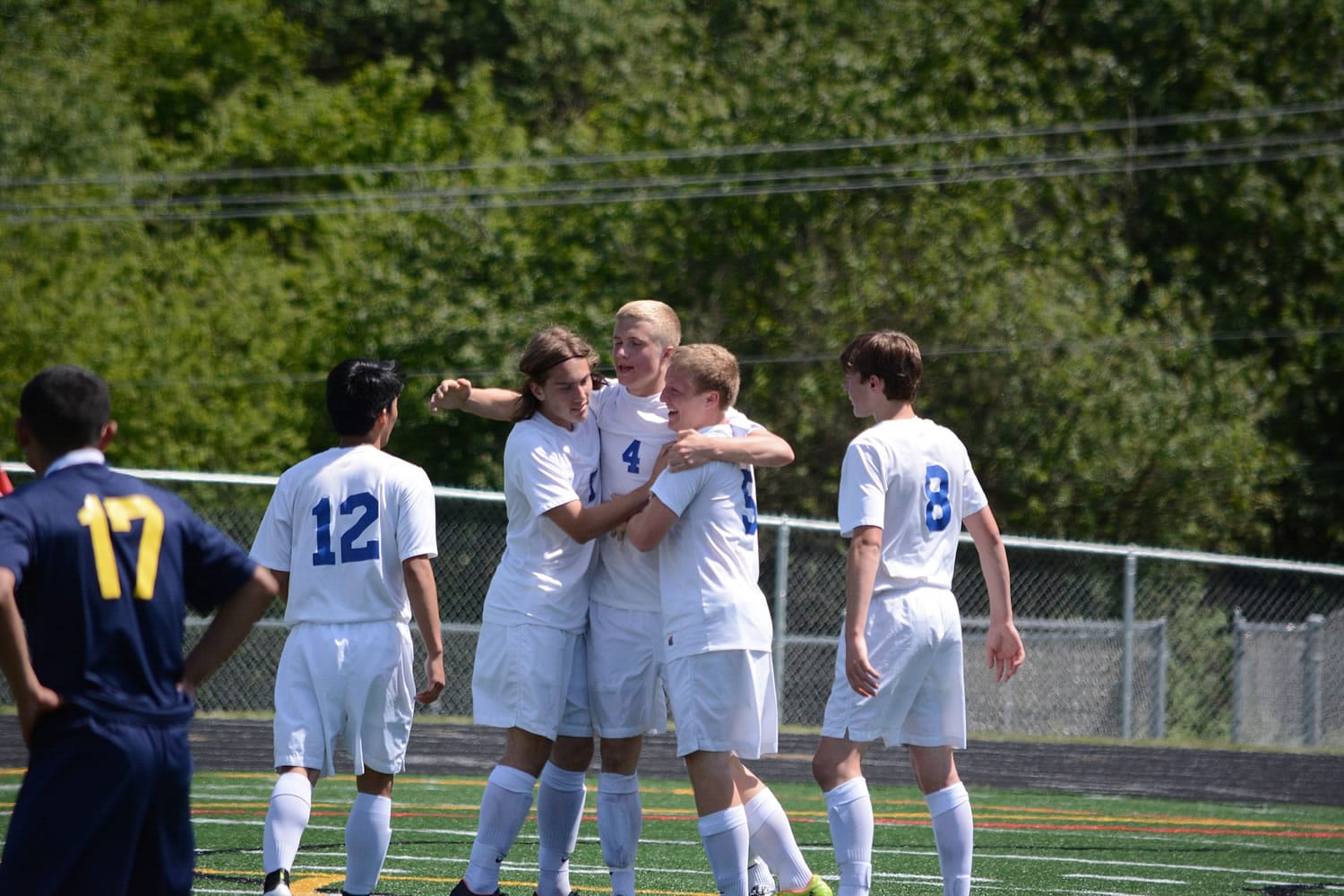 Ridgefield's Max Hauser (4) is congratulated by teammates after scoring the winning goal late in a 2A district boys soccer match Saturday, May 9, 2015, in Ridgefield.