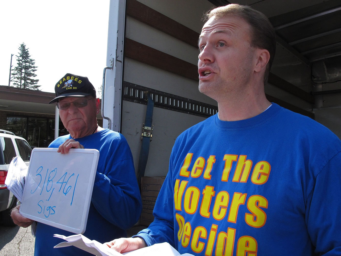 Initiative promoter Tim Eyman, right, and his partner, Jack Fagan, arrive at the state Elections Division office in 2012 to turn in signatures for an initiative in Olympia.