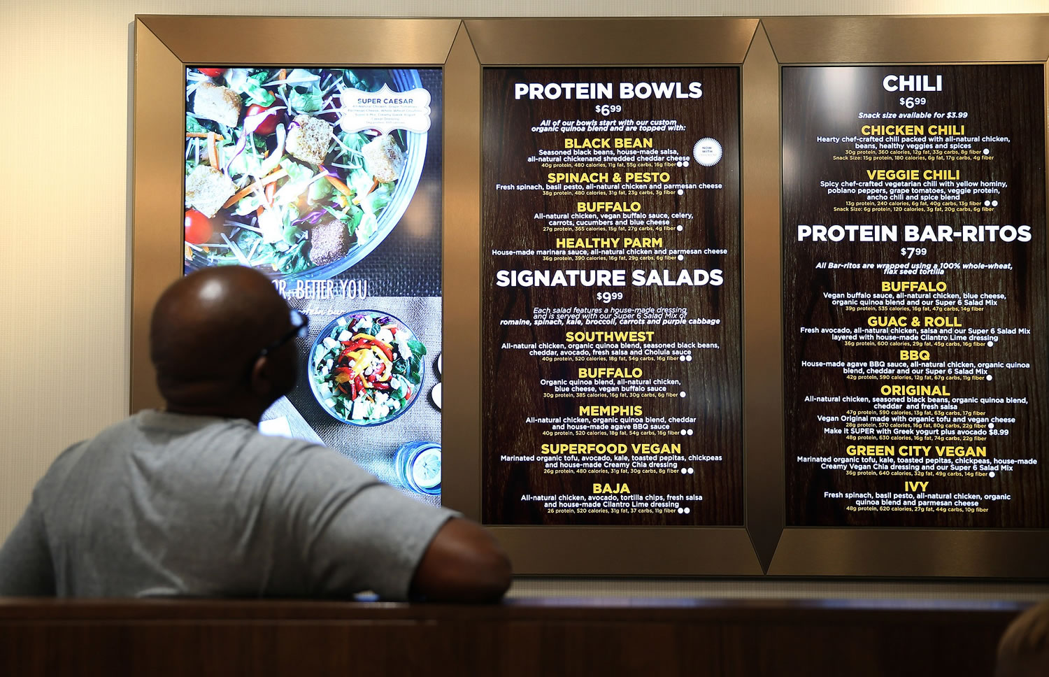 A customer reads the menu before moving forward to order at the Protein Bar in Chicago.