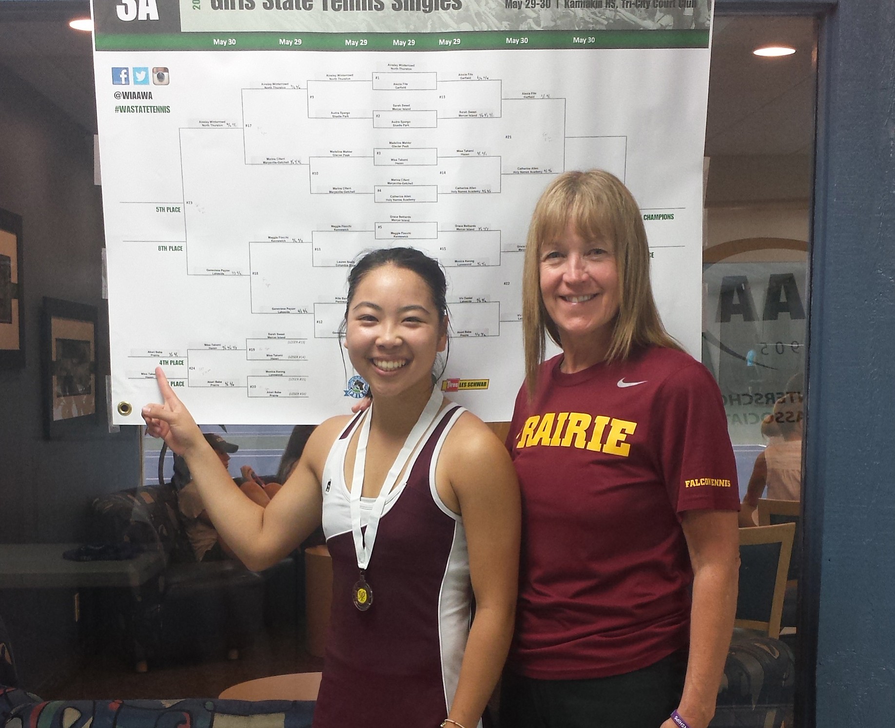 Prairie senior Akari Baba, with coach Chris Lindquist, points to her name on the 3A singles bracket after placing fourth at state on Saturday in Kennewick.