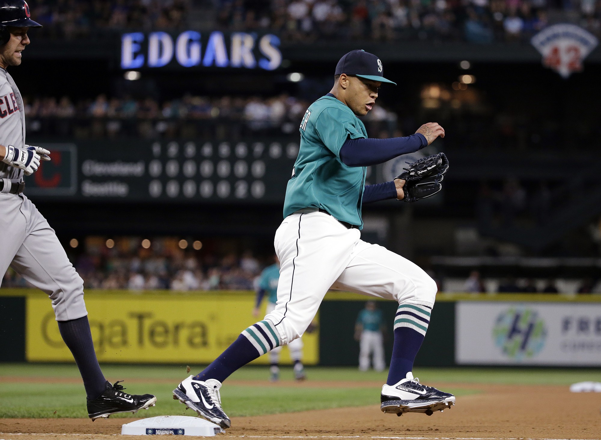 Seattle Mariners starting pitcher Taijuan Walker, right, beats Cleveland Indians' David Murphy to first base for an out in the eighth inning Friday, May 29, 2015, in Seattle.