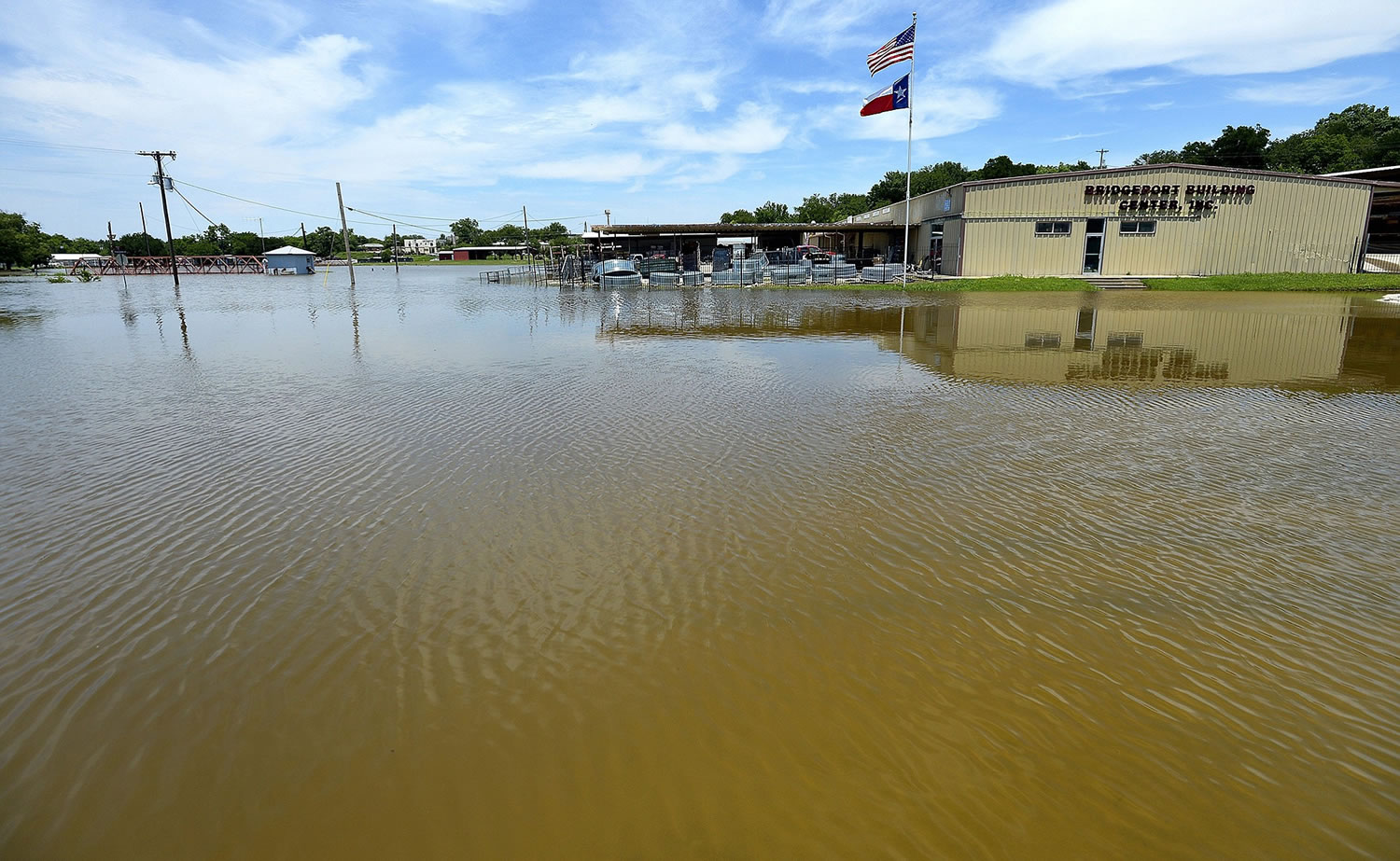 Floodwaters surround Bridgeport Building Center on Monday in Bridgeport, Texas. Tarrant Regional Water District officials say the West Fork of the Trinity River has grown to three-quarters of a mile wide around Boyd, Texas.