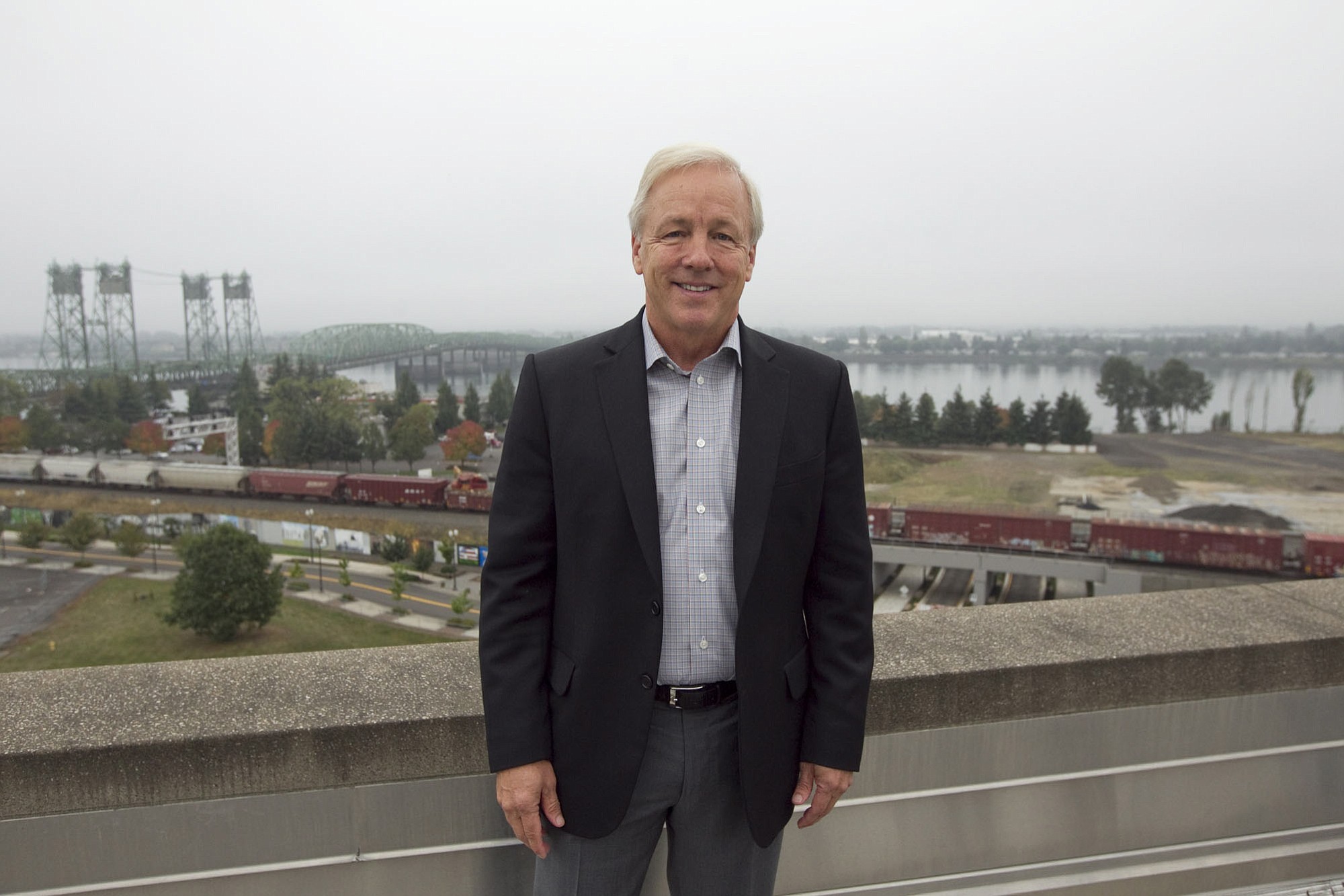 Barry Cain of Gramor Development poses for a photo on roof of city hall in Vancouver Thursday October 9, 2014. The area in the background will be the site of a $1.3 billion commercial/residential redevelopment of the city?s waterfront.
