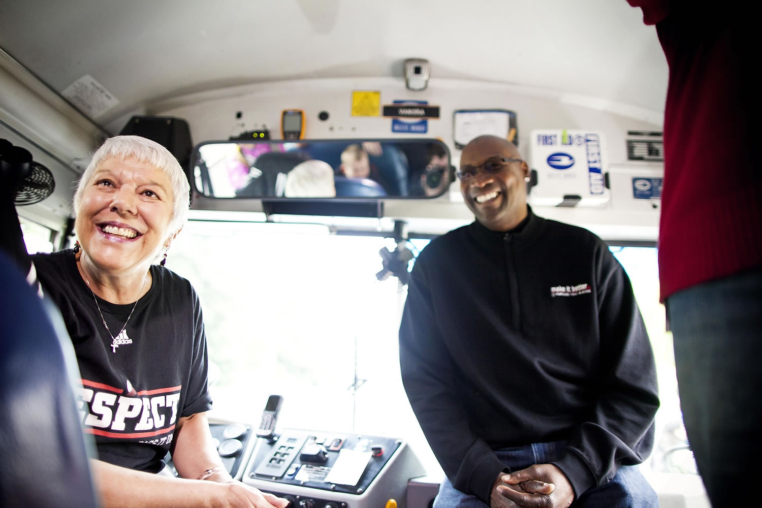 Vanora Volk, left, a bus driver for Vancouver Public Schools, gets a visit with former Portland Trail Blazer Jerome Kersey on her bus as she is honored for demonstrating the spirit of Damian Lillard's &quot;Respect, Pass It On&quot; program.