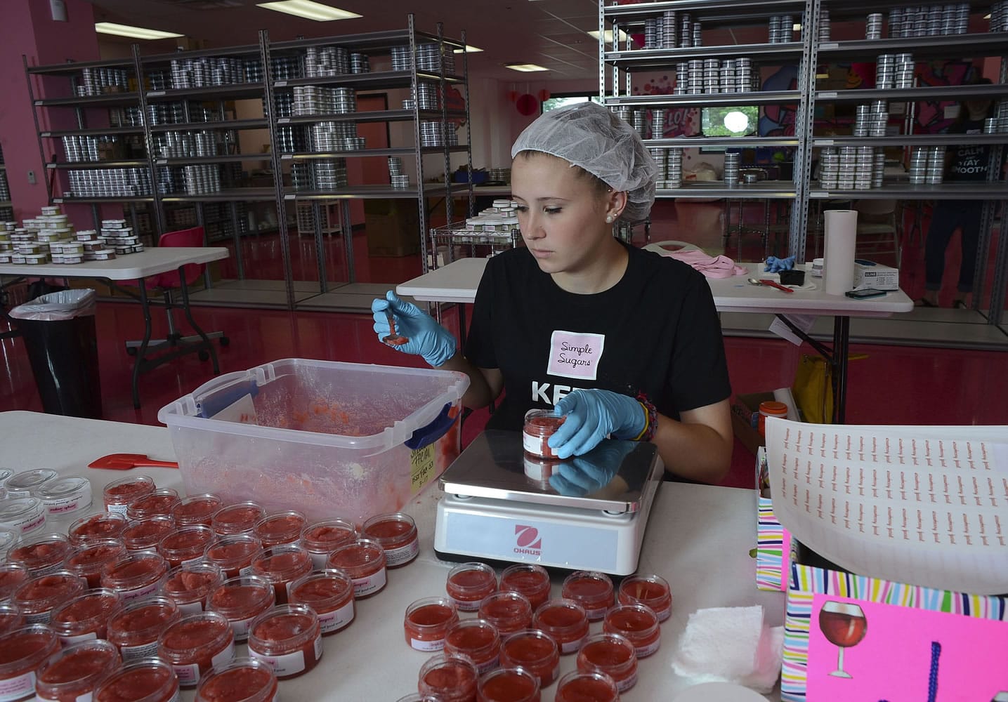 Shayna Reppermund measures strawberry facial scrub June 2 at Simple Sugars' new location in the RIDC Park in O'Hara Township, Pa.