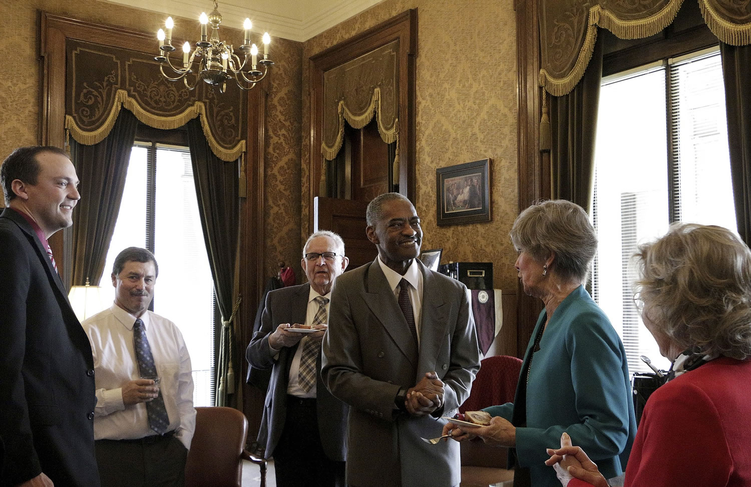 Washington State University President Elson Floyd, center, meets with lawmakers following the passage of a bill that opens the door for the college to open a medical school in Spokane on March 25in Olympia, Wash.