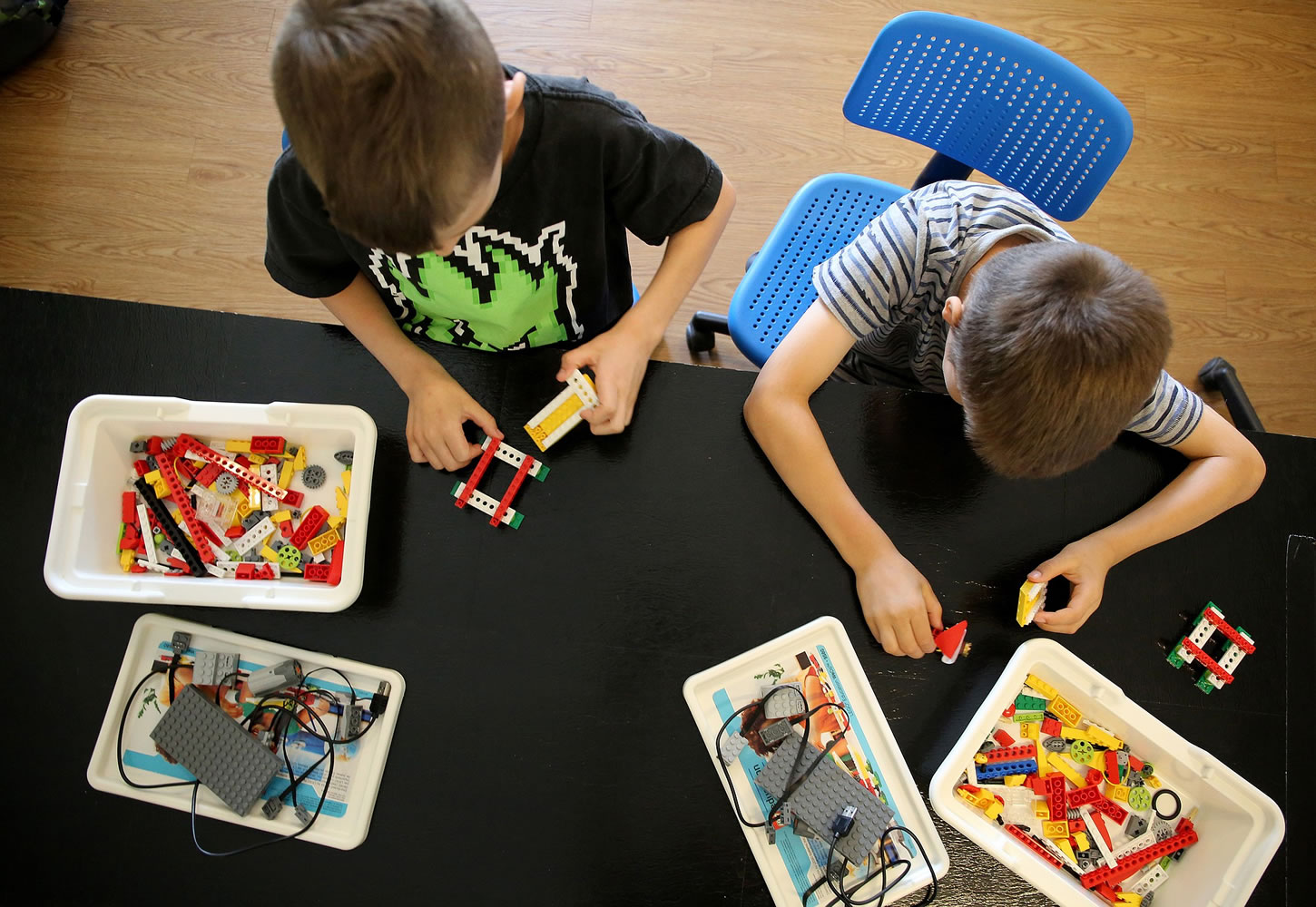 William Lerner, left, and William Kaegi learn coding skills while building a Lego robotic alligator during a sports-coding summer camp on June 16 in Oak Park, Ill.