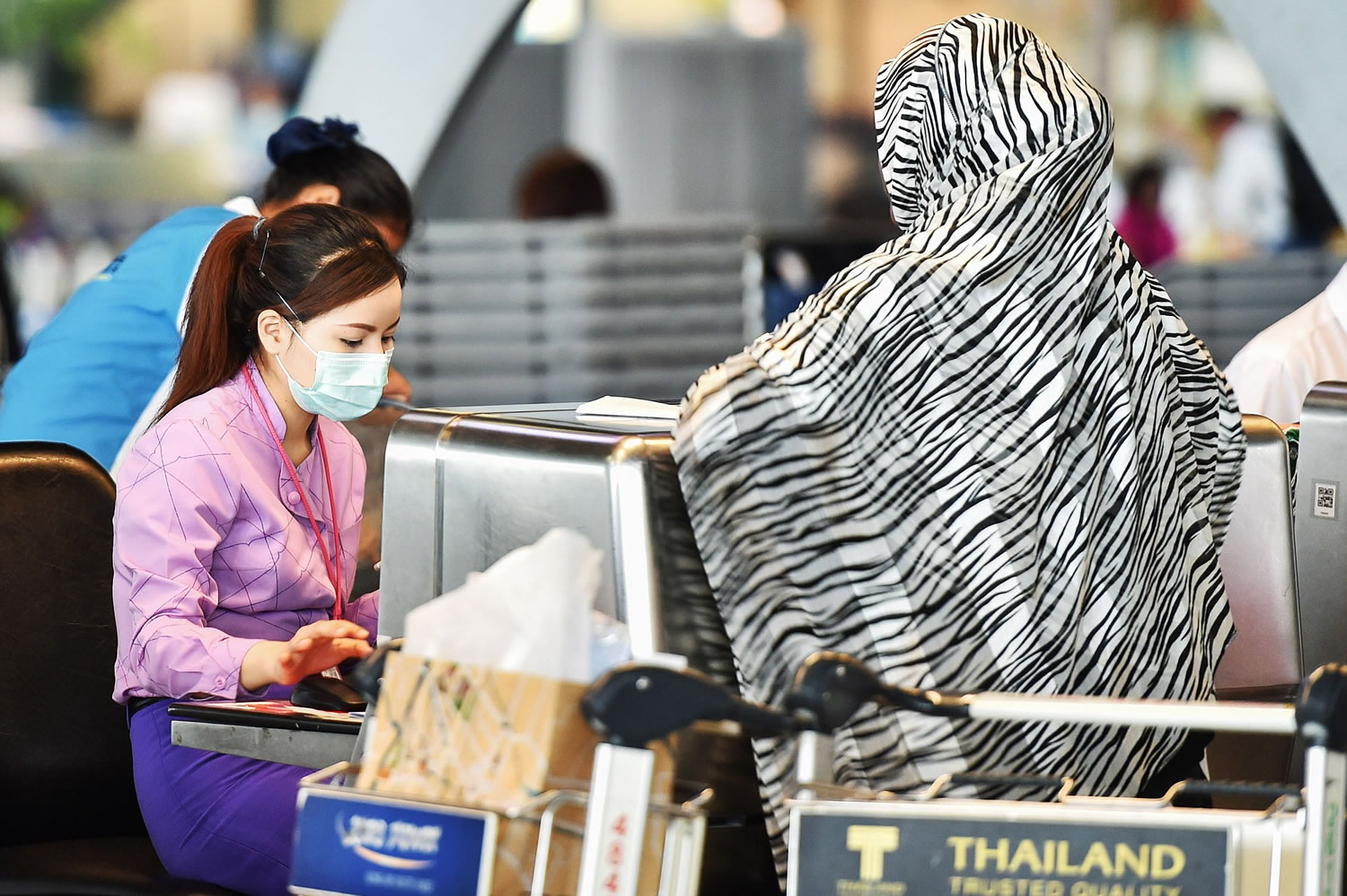 Li Mangmang/Sipa USA
A staffer is seen wearing a facial mask while working at the check-in counter at Suvarnabhumi Airport in Bangkok, Thailand, on June 20. Thailand's public health ministry recently confirmed the country's first case of the Middle East Respiratory Syndrome.