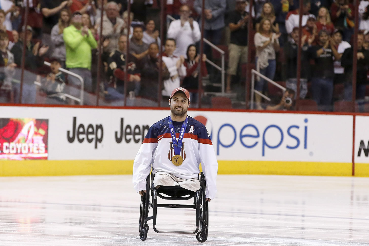 Josh Sweeney, U.S. sled hockey team member for the Paralympic Games, gets a standing ovation from the crowd as he is introduced before an NHL hockey game March 29 in Glendale, Ariz.