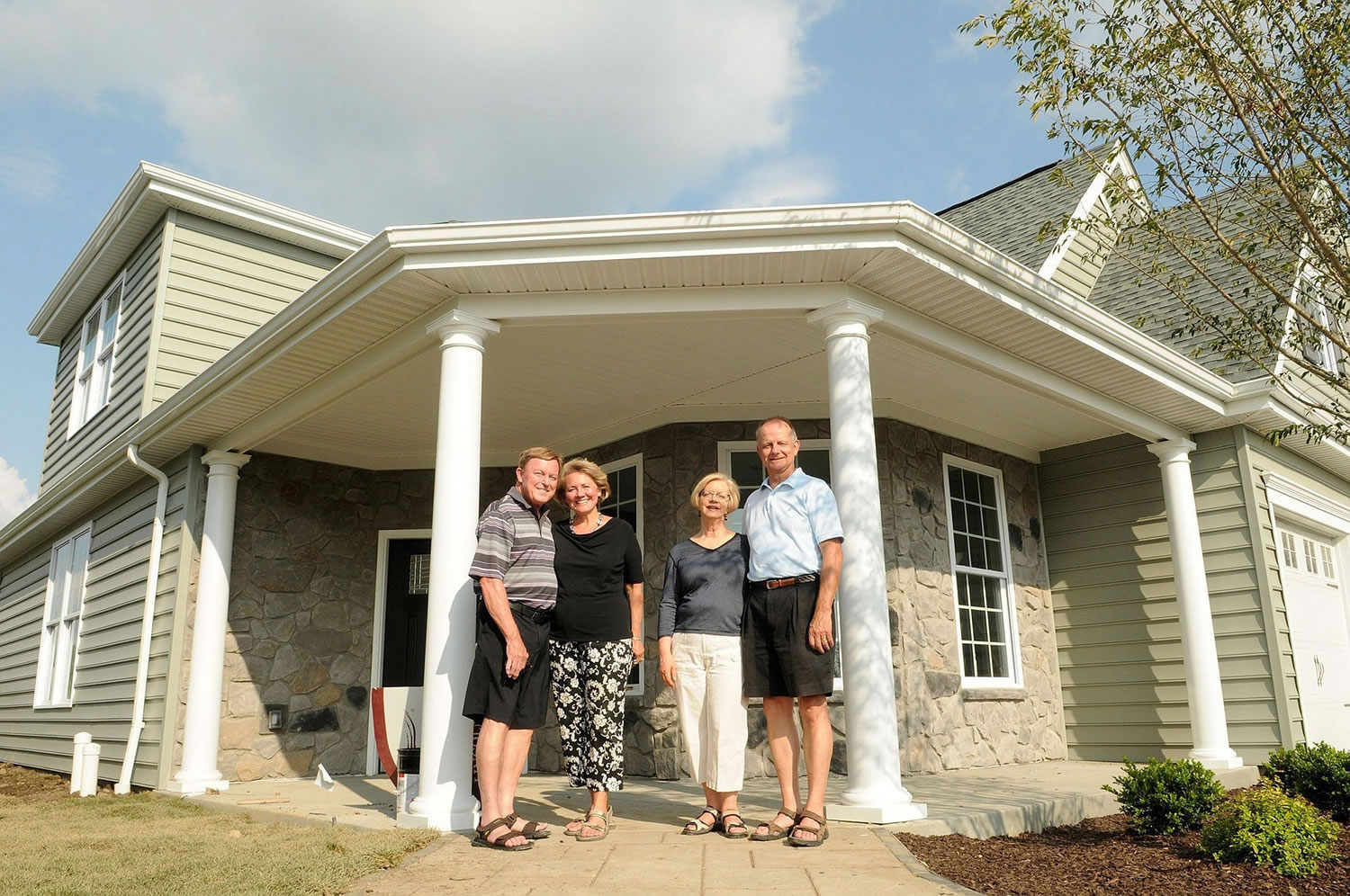 John and Judy Woffington, from left, join Rich and Kathy Jucha outside a model home in a Traditions of America housing development called Sewickley Ridge in Ohio Township, Pa., in June.