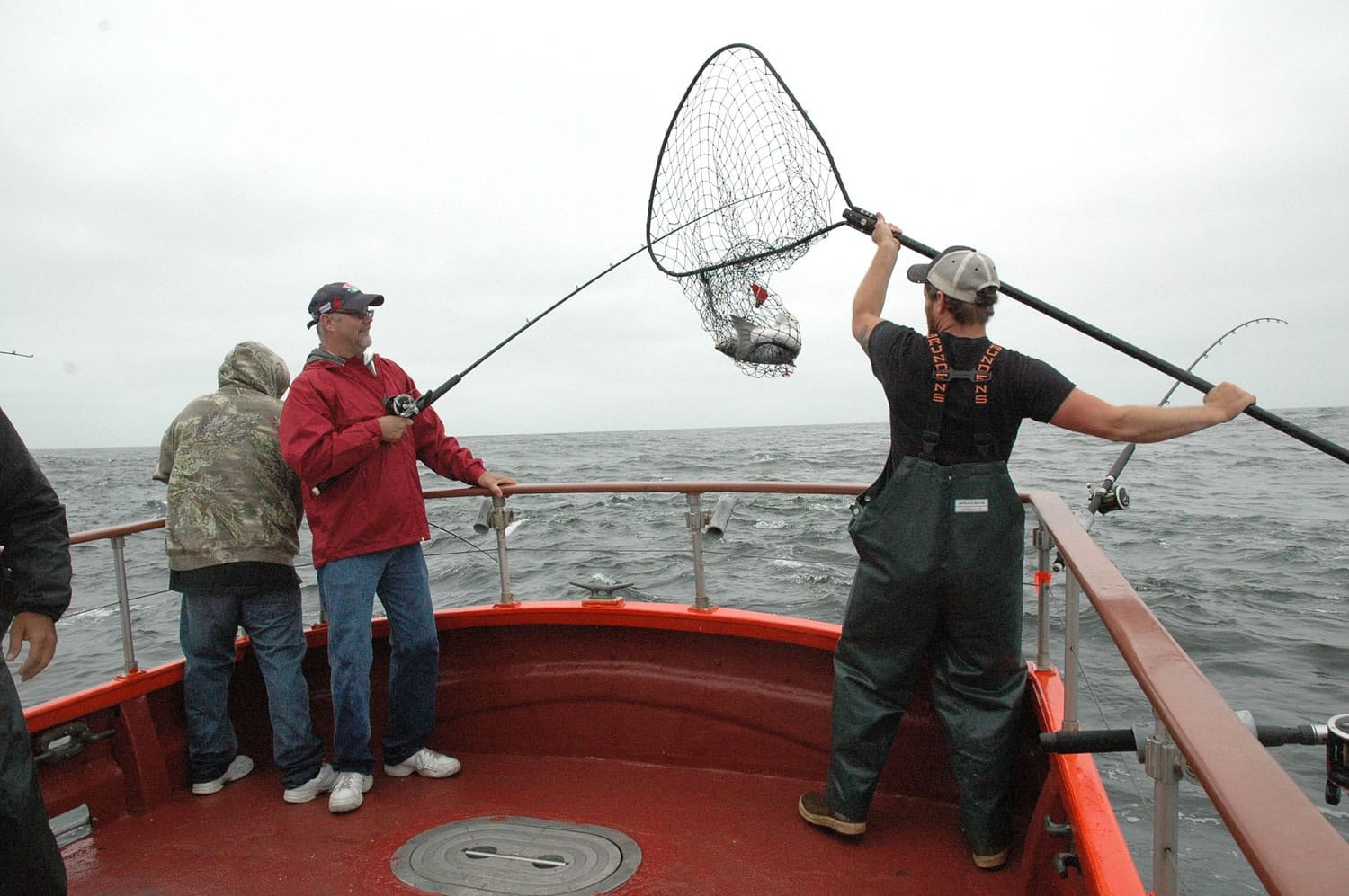 Deckhand Donald Pitts nets a salmon for a charter angler off the Washington in 2014.