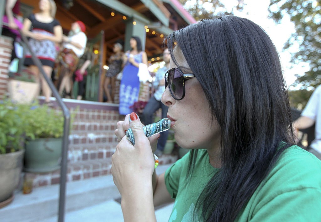 Amanda Gloudeman smokes a pipe with marijuana Saturday night at Mint Tea on Main Street in Vancouver.
