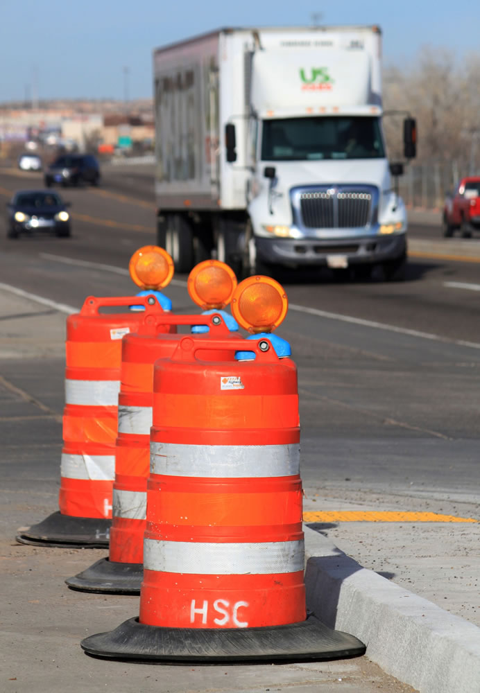 Orange barrels line US Route 550 as crews prepare to begin work on the highway in Bernalillo, N.M., on Friday, Feb. 19, 2015. New Mexico lawmakers are scrambling to find ways to fill the funding gap between shrinking state and federal revenues and highway infrastructure needs.