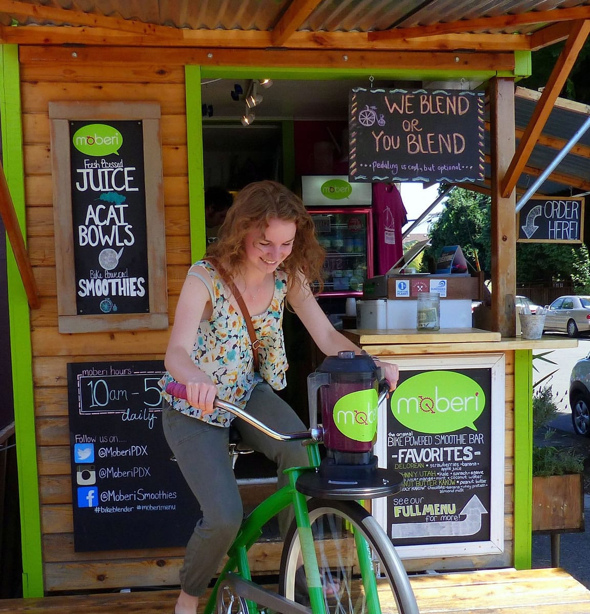 Carly Gray pedals to blend a Mr. Wonderful smoothie at the Moberi smoothie shack on Mississippi Avenue in Portland. &quot;We Blend or You Blend ...