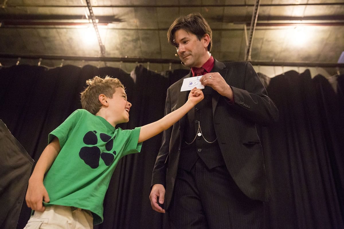 Max Minkin Horwitz, 8, assists magician Reynolds with a trick at Reynolds' family variety show July 27 at the Phinney Center in Seattle.