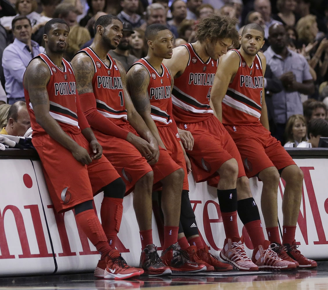 Portland Trail Blazers starters, from left, Wesley Matthews, LaMarcus Aldridge, Damian Lillard, Robin Lopez, and Nicolas Batum, sit on the scorers table during a timeout in the second half of Game 5 of a Western Conference semifinal NBA basketball playoff series against the San Antonio Spurs, Wednesday, May 14, 2014, in San Antonio. San Antonio won 104-82.