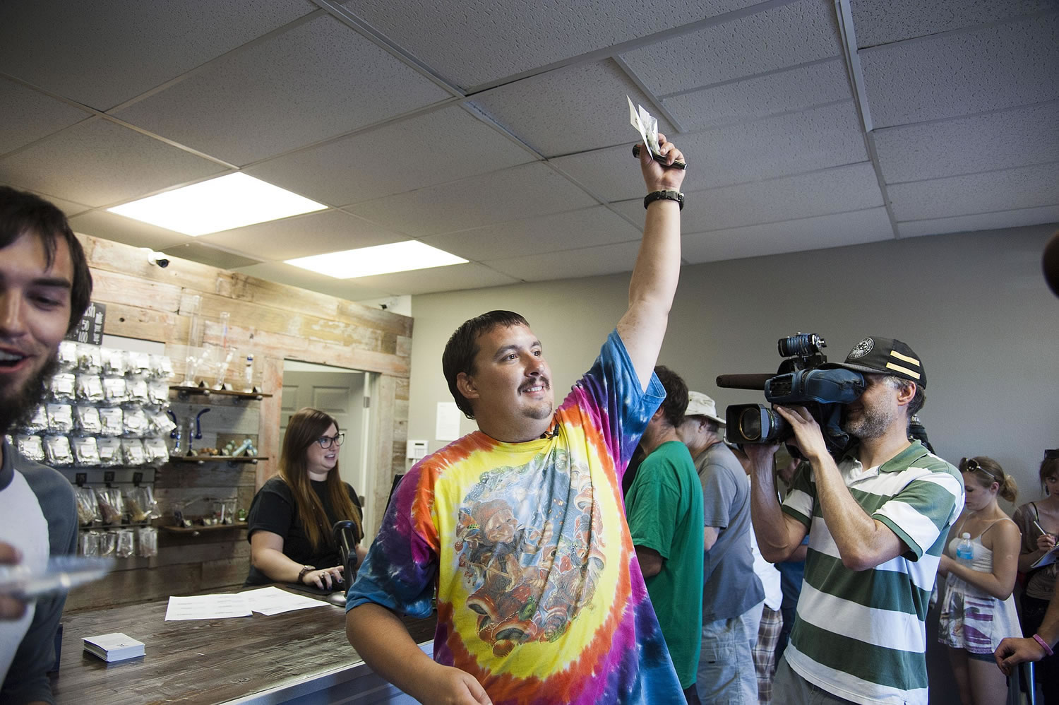 Associated Press files
Mike Boyd turns to the crowd outside, showing off the 4 grams of marijuana he bought as the first in line to legally purchase marijuana at Spokane Green Leaf on July 8, 2014.