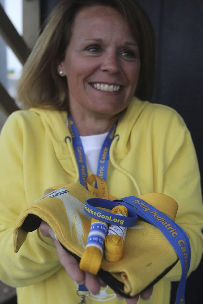 Vicky Zingale holds Go4theGoal laces, socks, brackets and lanyards, which are sold to benefit cancer patients at Akron Children's Hospital in Akron, Ohio.