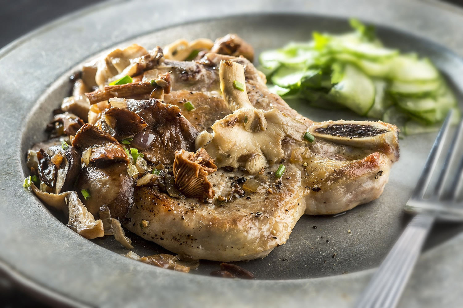 Golden pork chops smothered in sauteed chanterelles and accompanied by a simple and quick cucumber salad are a delicious way to use mushrooms this fall.