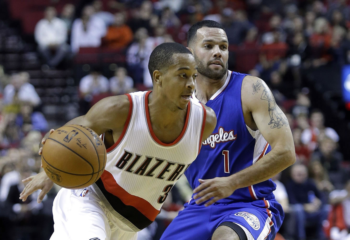 Portland Trail Blazers guard CJ McCollum, left, drives past Los Angeles Clippers guard J.J. Redick during the second half of an NBA pre-season basketball game in Portland, Ore., Sunday, Oct. 12, 2014.