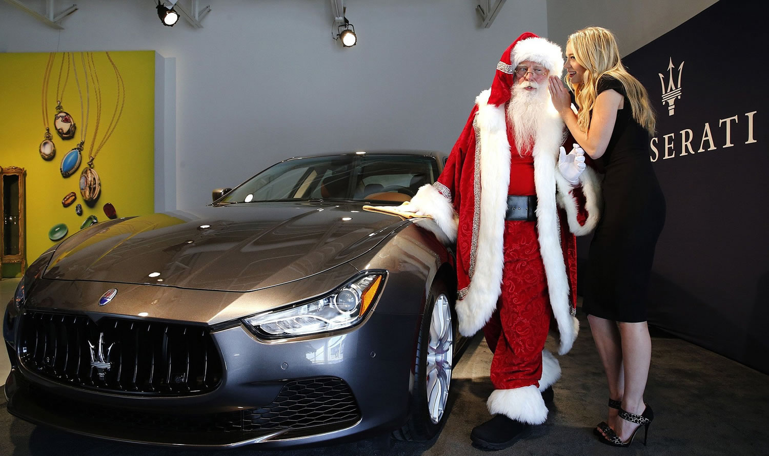 Photos by David Woo/Dallas Morning News
Roxanna Redfoot whispers in Santa Brady White's ear as they showcase the 100th anniversary Neiman Marcus Limited-Edition Maserati Ghiblis Q4 all-wheel drive during the 2014 Christmas Book release press event Oct. 7 in Dallas.