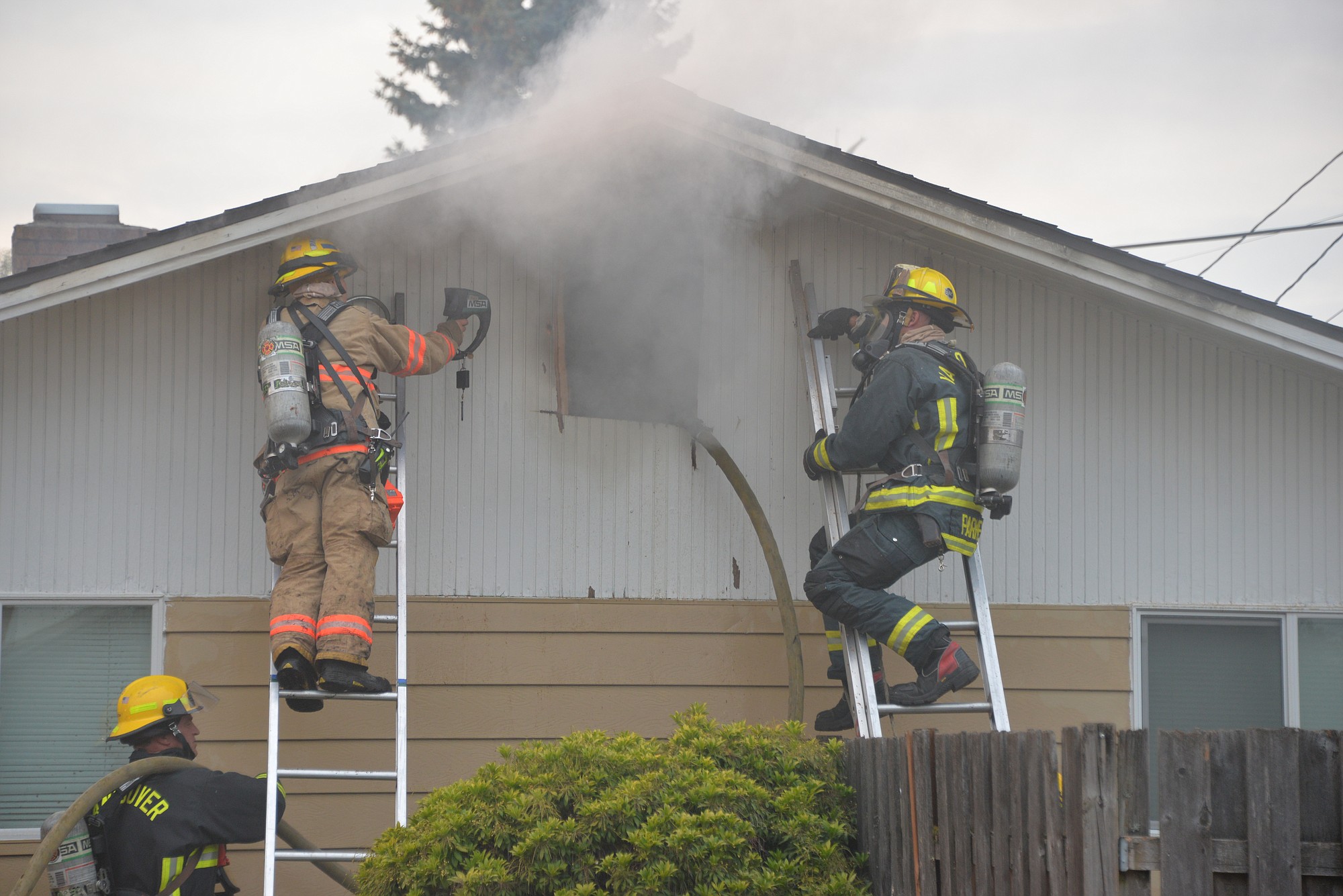 Firefighters battle an attic fire in a home at 307 S.E. 105th Ave.
