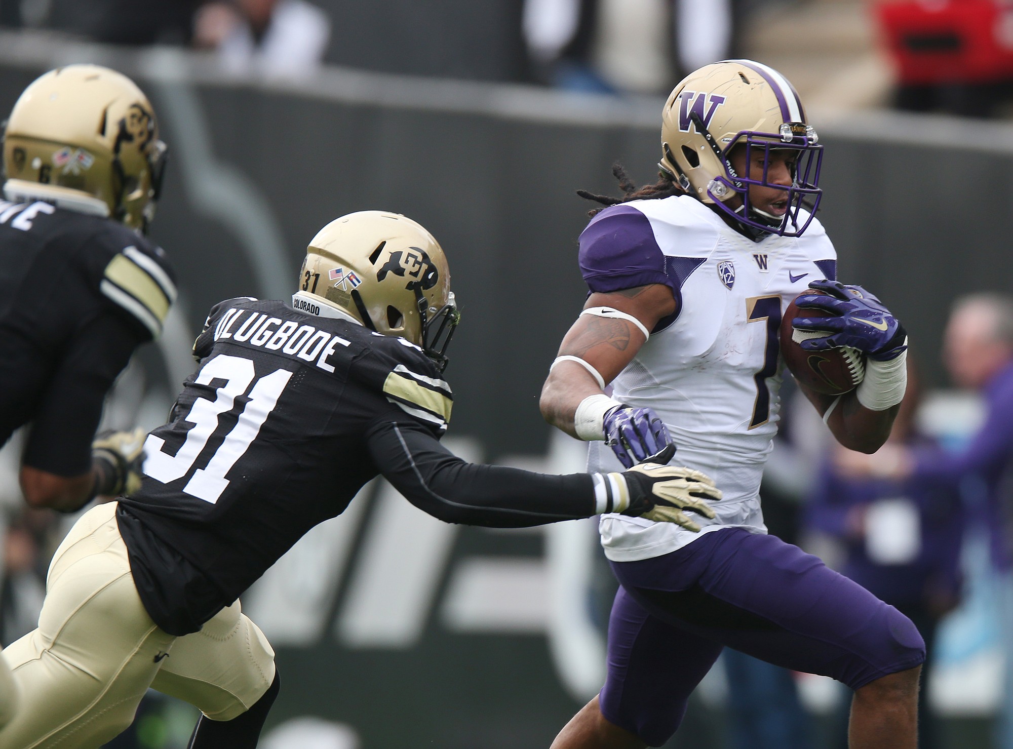 Washington runing back Shaq Thompson, right, eludes tackle by Colorado linebacker Kenneth Olugbode in the second quarter of an NCAA college football game in Boulder, Colo., on Saturday, Nov.