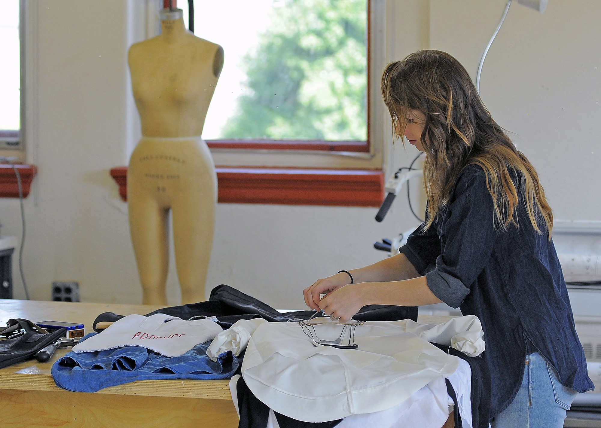 Designer Erin Sudeck organizes the outfits she has created at the Maryland Institute College of Art Mount Royal Station.