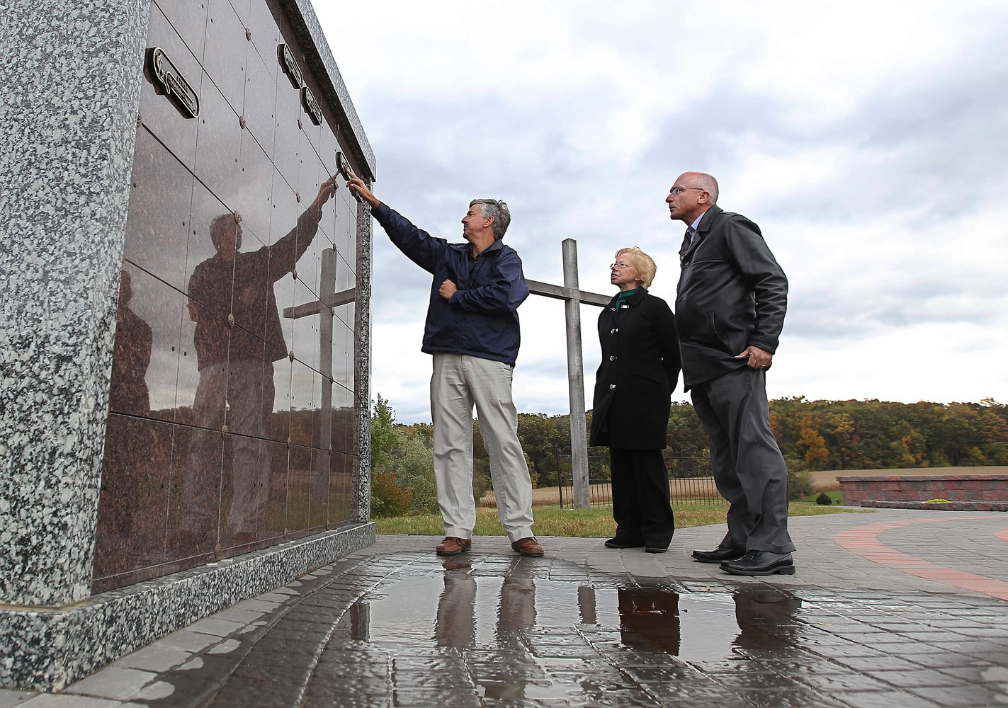 Hopewell United Methodist Church Senior Pastor Steve Morton, left, Debra Boyd, director of lay ministries, and Pastor Dan Hepner examine the name plates on one of the newly constructed columbaria Oct.
