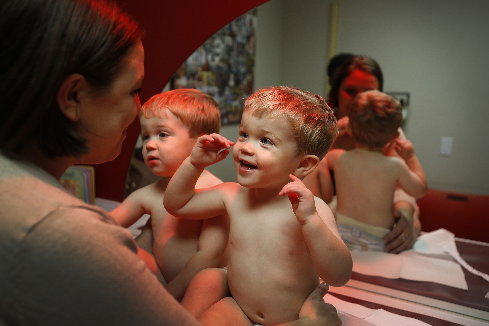Rachel Gipson, 32, entertains her twin sons, Simon and Henry, age 2, while waiting to be seen by Dr. Lisa Stern, 54, a pediatrician.