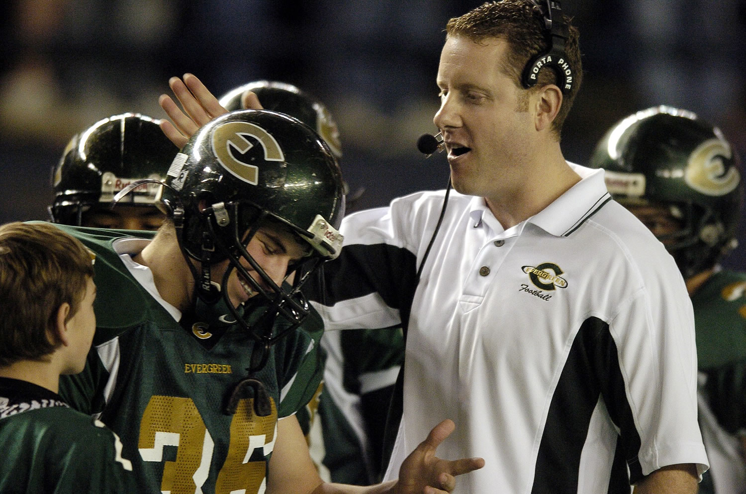 Evergreen High School football coach Cale Piland congratulates Kane Rable during introductions before the start of the 4A state football championship game in 2004.