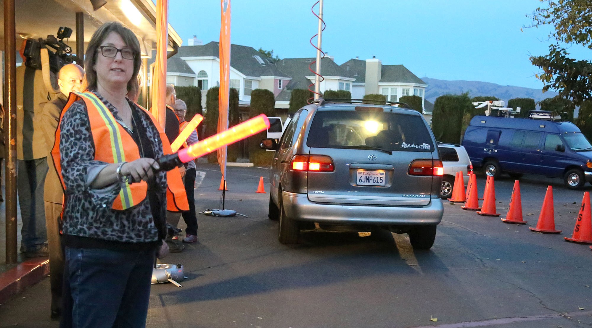 Amy Wilhelm directs traffic at the start of the drive-thru prayer service earlier this month at Holy Spirit Church in Fremont, Calif. The service is offered from 5 to 7 p.m.