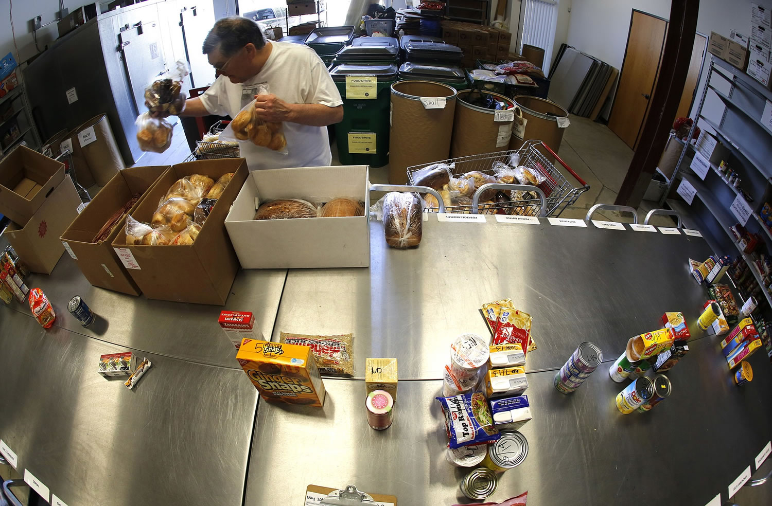 Volunteer Martin Shellabarger sorts donated food items at Families Forward'S warehouse-sized pantry in Irvine, Calif.