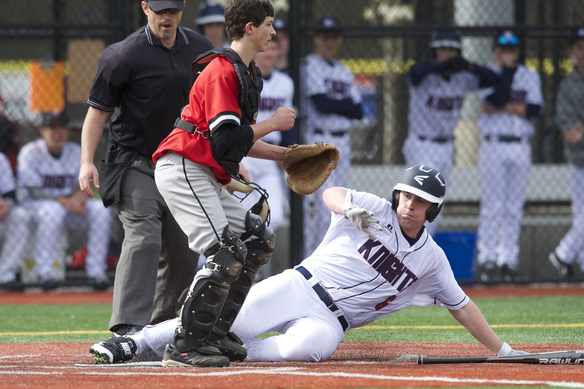 Preston Danberg of King's Way Christian slides home to score in the first game of a doubleheader on the all-weather field at Luke Jensen Sports Park.