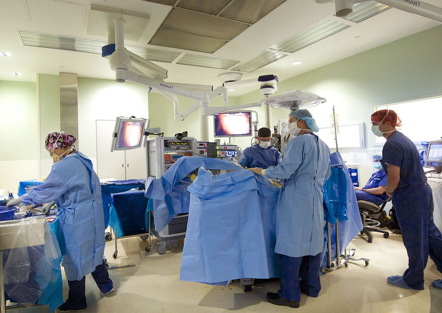 Dr. Scott Rushing, center, prepares a 51-year-old patient for a single-site hysterectomy Wednesday in an operating room at PeaceHealth Southwest Medical Center. The single-site surgery uses only one incision -- a 2-centimeter incision in the belly button -- and leaves no visible scar.