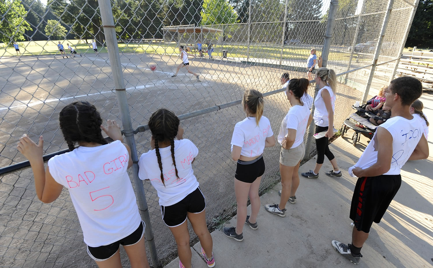 The Ballics watch from their dugout as a teammate kicks the ball at David Douglas Park on a Thursday in late June.